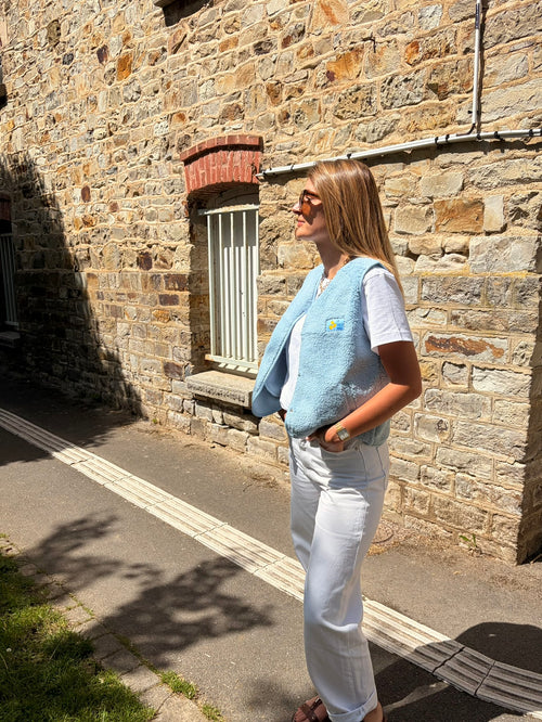 Alison porte le Gilet sans manches bouclette bleu ciel ROMA col V patch brodé La Dolce Vita – Marcelle Ouest